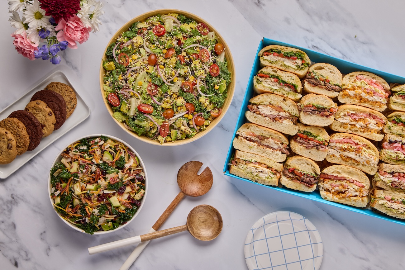 Catering boxes of sandwiches, salads, and cookies